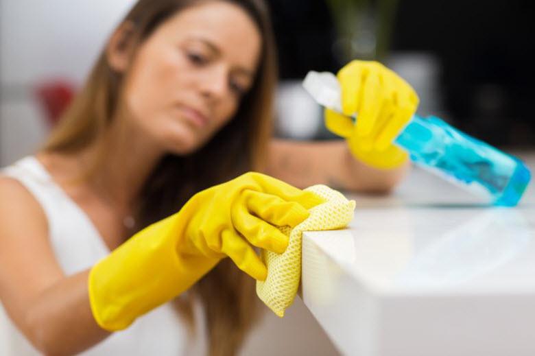 1.1-Mujer-Limpiando-mesa-blanca-con-guantes-amarillos