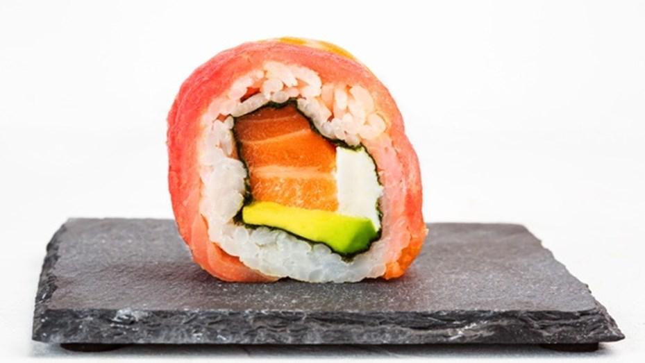 primer-plano-rollo-sushi-sobre-placa-piedra-negra_181624-22537