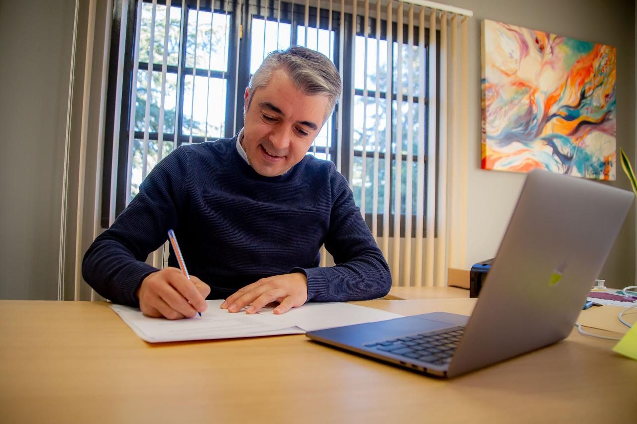 Bragagnolo firmando el pacto
