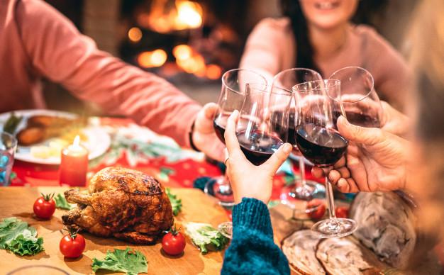 familia-brindando-vino-tinto-divirtiendose-cena-navidad_101731-200