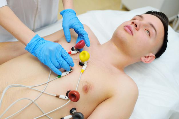 doctor-cardiologia-mujer-joven-bonita-coloca-sensores-electronicos-goma-vacio-electrocardiograma-o-electrocardiograma-cuerpo-paciente-masculino-prevencion-enfermedades-cardiovasculares_74906-2227