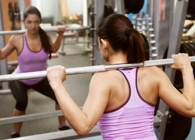 chica-gimnasio-levanta-barra-frente-al-espejo_8353-5694